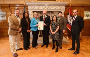 Gov. Asa Hutchinson presents proclamation to Laura Fine and ASBTDC staff