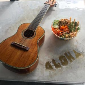 Ohia Poke bowl of poke with the word "aloha" and ukulele