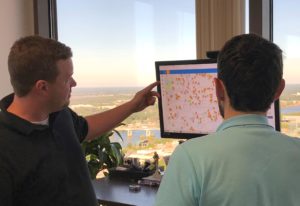 Matthew Young and a colleague look at a Listing Village map on a computer monitor