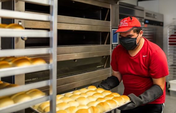 Rockin' Baker employee with tray of buns