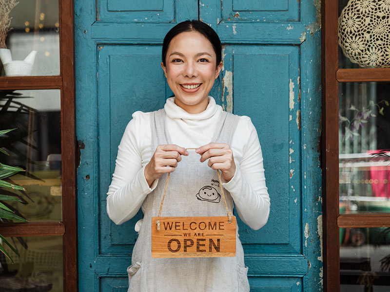 Proud small business owner with we are open sign