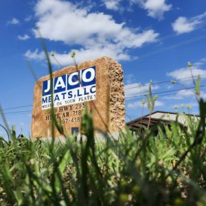 JACO Meats sign with building in background