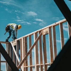 Construction working framing building with blue sky in background
