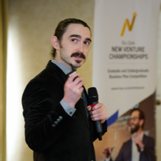 Joshua Upshaw speaking while holding a microphone